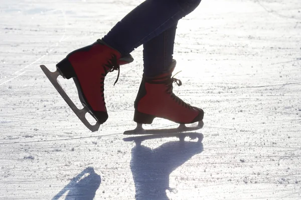 Pies en patines rojos en una pista de hielo. pasatiempos y ocio. invierno s —  Fotos de Stock