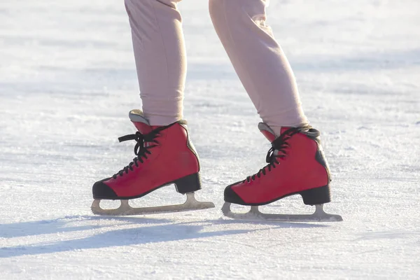 Füße in roten Schlittschuhen auf einer Eisbahn. Hobbys und Freizeit. Winter — Stockfoto