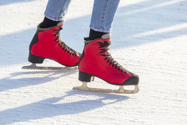 脚踏在溜冰场上的红色冰鞋。业余爱好和休闲。冬天的 — 图库照片