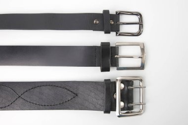 three black leather belt on a white background. items and clothi