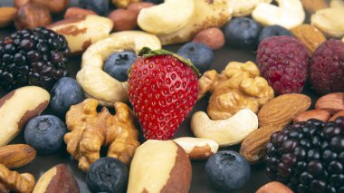 farklı meyveler ve fındıklar tabakta. Vitamin proteinleri ve iyileşme