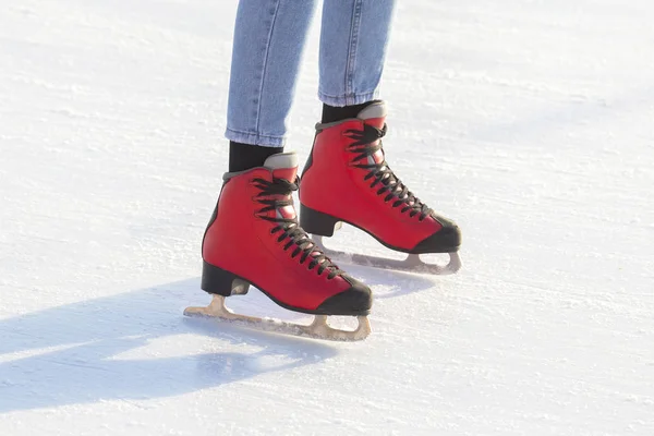 Piernas de una chica patinando sobre hielo en una pista de hielo. pasatiempos y ocio . — Foto de Stock