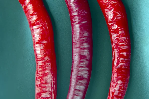 Pimientos rojos frescos picantes sobre un fondo verde de cerca —  Fotos de Stock