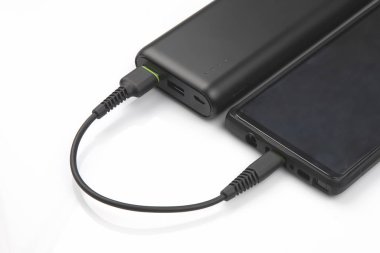 Power Bank beyaz arka planda akıllı telefon bataryası şarj ediyor. di
