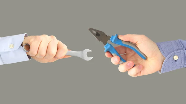 Hands with different working tools on gray background. Industry — Stock Photo, Image