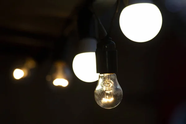 Lâmpadas LED e elétricas brilham na rua. iluminação elétrica de — Fotografia de Stock