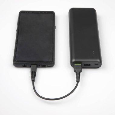 powerbank charges a smartphone on a white background. digital te