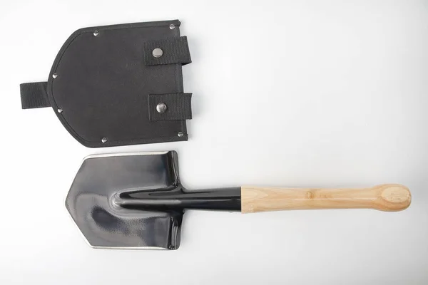 Small shovel for tourism and earthworks with a wooden handle in — Stok fotoğraf