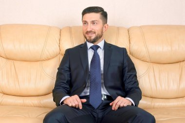 deri koltukta oturan takım elbiseli başarılı iş adamı