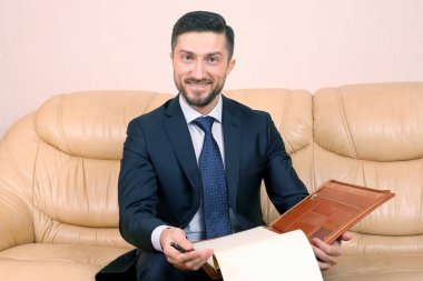 successful business man with business documents sitting on a lea
