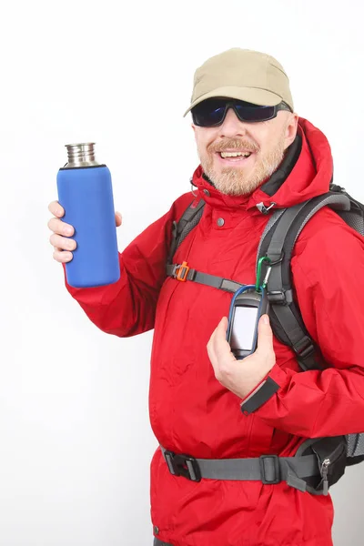 Tourist traveler in a red jacket shows a metal bottle for water — Stockfoto