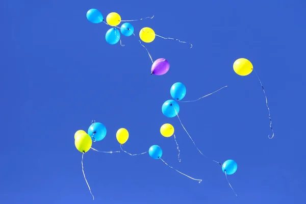 Balões multicoloridos voando no céu azul — Fotografia de Stock