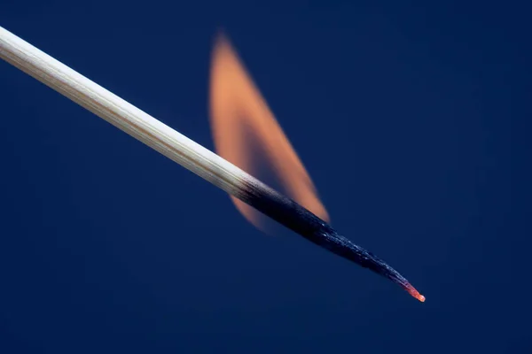 Jogo em chamas num fundo azul escuro — Fotografia de Stock