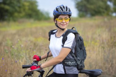 Doğada bisikleti olan güzel bir bisikletçi kız. Sağlıklı yaşam tarzı ve spor. Boş zaman ve hobiler.
