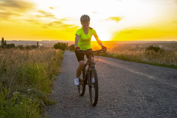 Schöne Radfahrerin Auf Dem Fahrrad Auf Der Straße Richtung Sonnenuntergang — Stockfoto