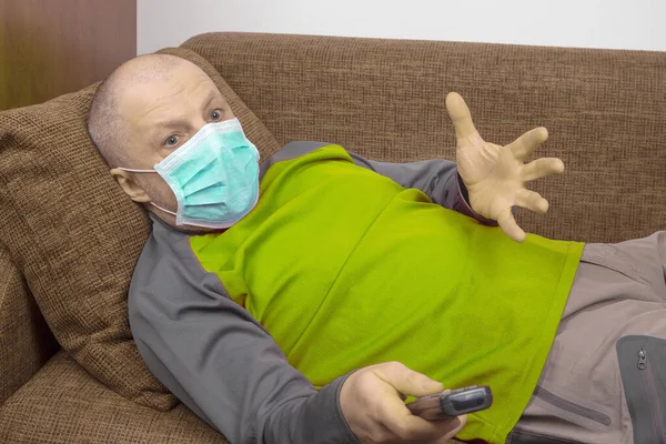 Man Quarantine Home Medical Mask His Face Lies Couch Watches — Stock Photo, Image