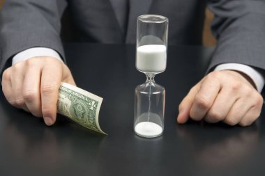 Para ve kum saati bir iş adamının arka planında. İş zamanı dağılımı. Karar verme zamanı. İnsan maaşı.
