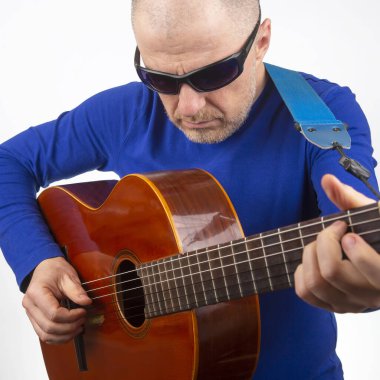 Adam beyaz arka planda klasik gitar çalıyor. müzik yaratıcılığı. string müzik enstrümanı