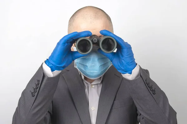 Homem Terno Negócios Uma Máscara Médica Luvas Protetoras Olha Por — Fotografia de Stock