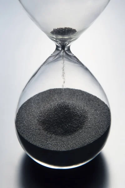 Hourglass on a light background. Time is money. Business solutions in time.