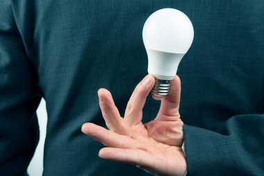 Bir iş adamının eli bir LED tutuyor.