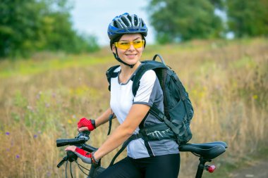 Doğada bisikleti olan güzel bir bisikletçi kız. Sağlıklı yaşam tarzı ve spor. Boş zaman ve hobiler.