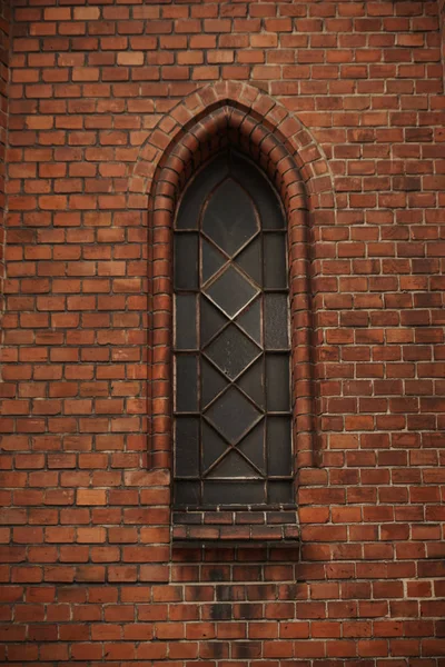 Side window of the medieval church. Gothic style window.