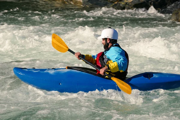 Side Profile of Extreme Kayaker Paddling in Raging River of White Water Rapids Stock Picture