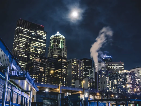 Αστικό τοπίο νύχτα κοιτώντας ψηλά κτίρια και θολό φεγγάρι — Φωτογραφία Αρχείου