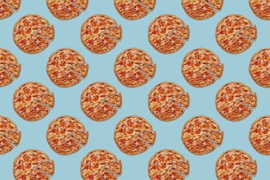 Turkuaz arka planda kesilmiş lezzetli bir pizza. Moda konsepti.