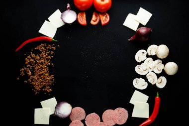 Siyah bir konsept arka planda pizza yapmak için gerekli malzemeler.