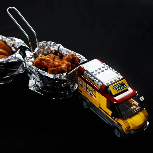 Pizza delivery machine carries chicken wings closeup photo