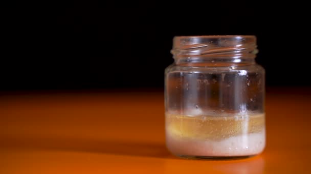 Bicarbonato de sódio em um jarro de vidro no qual o vinagre se acrescentou. efeito químico interessante. Conceito de vídeo em um fundo escuro — Vídeo de Stock