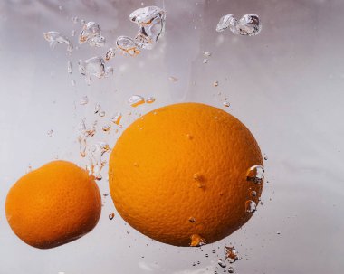 Portakal ve mandalina suda yüzer. Beyaz arkaplan