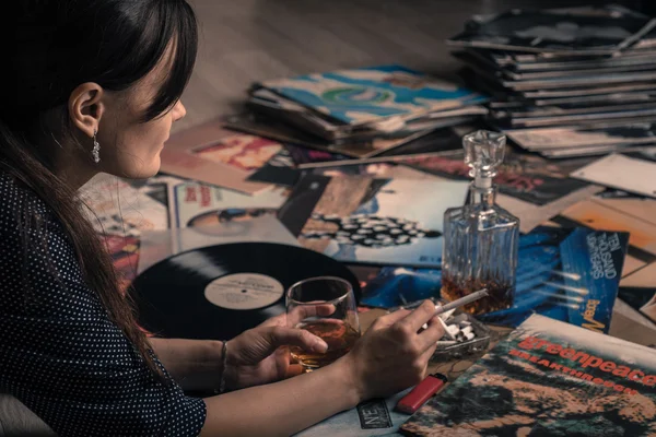 RUSIA. Retrato de una hermosa chica, whisky de vidrio, escuchando música de vinilo LP discos vintage Imagen de stock