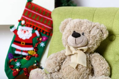 Oyuncak ayı Noel ağacının altında bir sandalyede