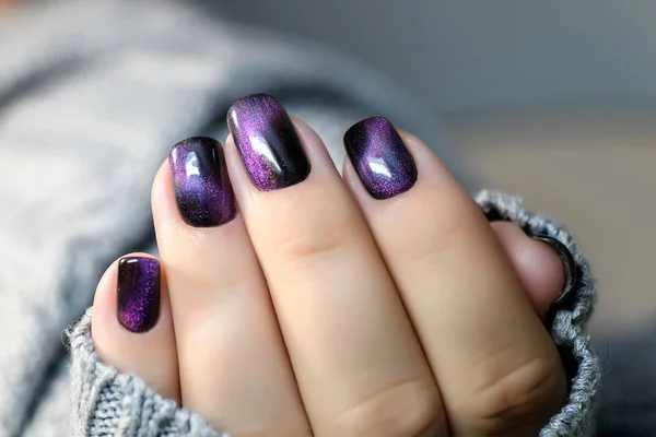 Beautiful nail polish in hand, purple nail art manicure, gray background — Stock Photo, Image