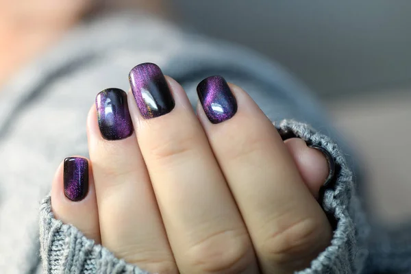 Hermoso esmalte de uñas en la mano, manicura de uñas de color púrpura, fondo gris —  Fotos de Stock