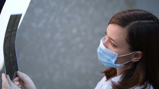 Kvinnlig läkare undersöker en röntgen av en patient. Medicinsk personal diskuterar röntgenresultat — Stockvideo