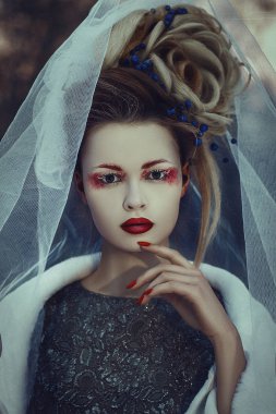Güzel model yaratıcı makyaj ile bir kış ormanda poz