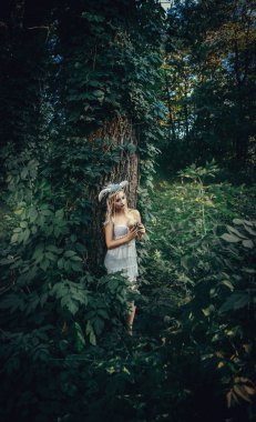 Güzel model beyaz boynuzları olan bir ormandaki poz 