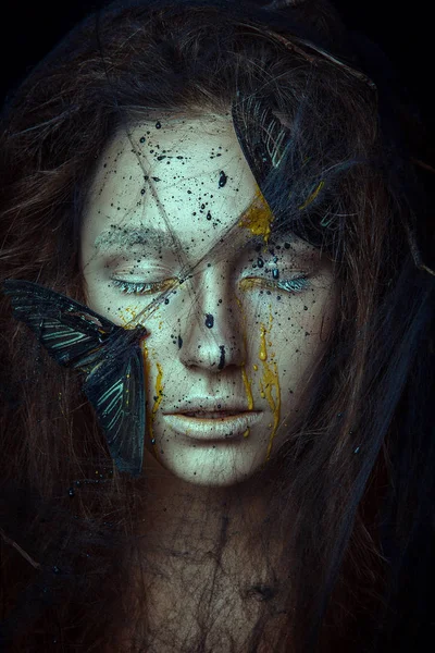 The Beautiful model is posing with the butterflies on her face