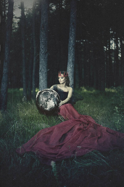 Красивая модель позирует в лесу с луной
