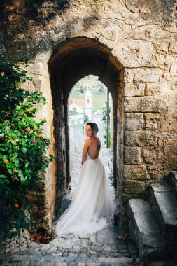 Beyaz elbiseli kadın kalede poz veriyor.