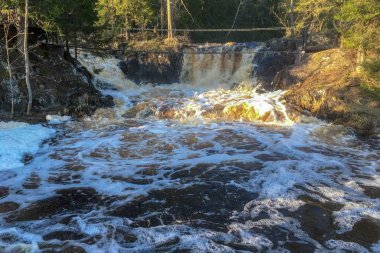 Çalkantılı şelaleler göle akıyor.