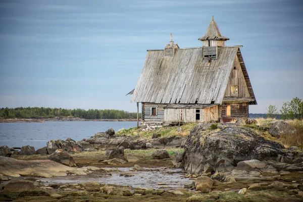 Старый деревянный дом стоит на берегу — стоковое фото