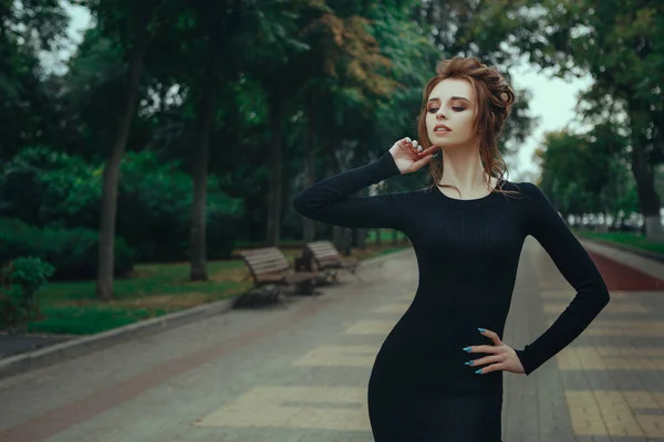 Chica en vestido negro posando en el Parque — Foto de Stock