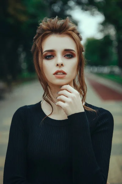 Девушка в черном платье позирует в парке — стоковое фото