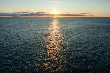 Güneş Faroe Adaları 'ndaki zümrüt okyanusa batıyor.