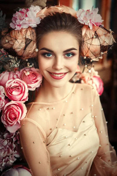 Hermosa modelo está posando con maquillaje creativo y flores — Foto de Stock